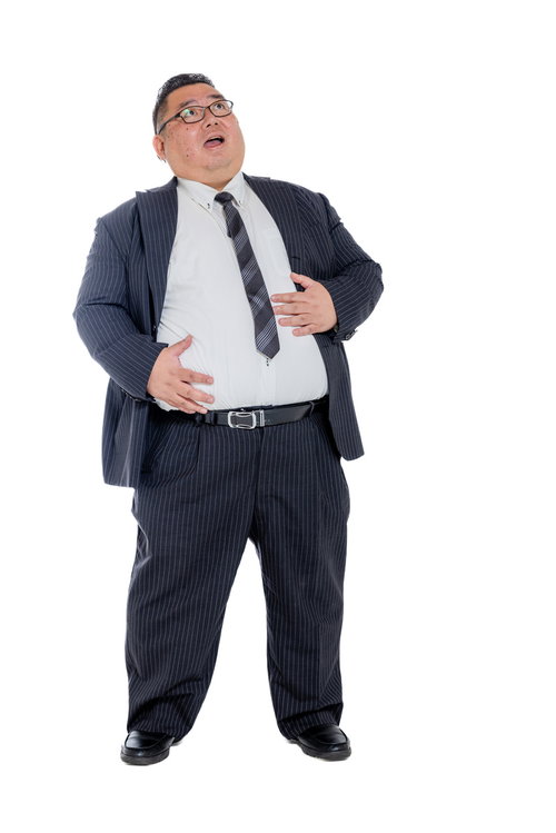 両手でお腹をさするスーツ姿の満腹の中年会社員男性