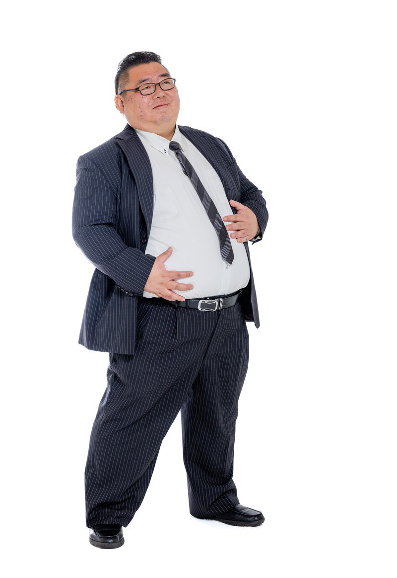 お腹を気にするスーツ姿の男性。ワイシャツがパツパツに張っている［モデル：ダルマ親方］