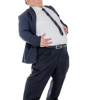 食べすぎてお腹パンパンの男性会社員、ベルトが食い込むの写真