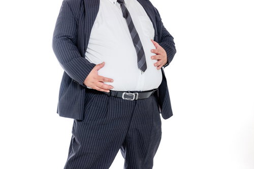 はち切れそうなお腹をさする太っちょ会社員
