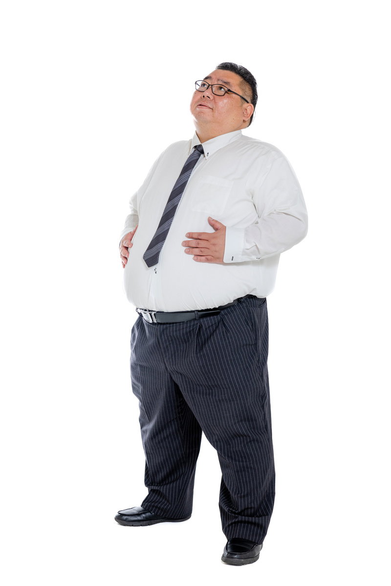 お腹が膨らんだスーツ姿の男性が両手でお腹を摩っている［モデル：ダルマ親方］