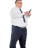 スマートフォンを操作する膨よかな男性会社員の写真