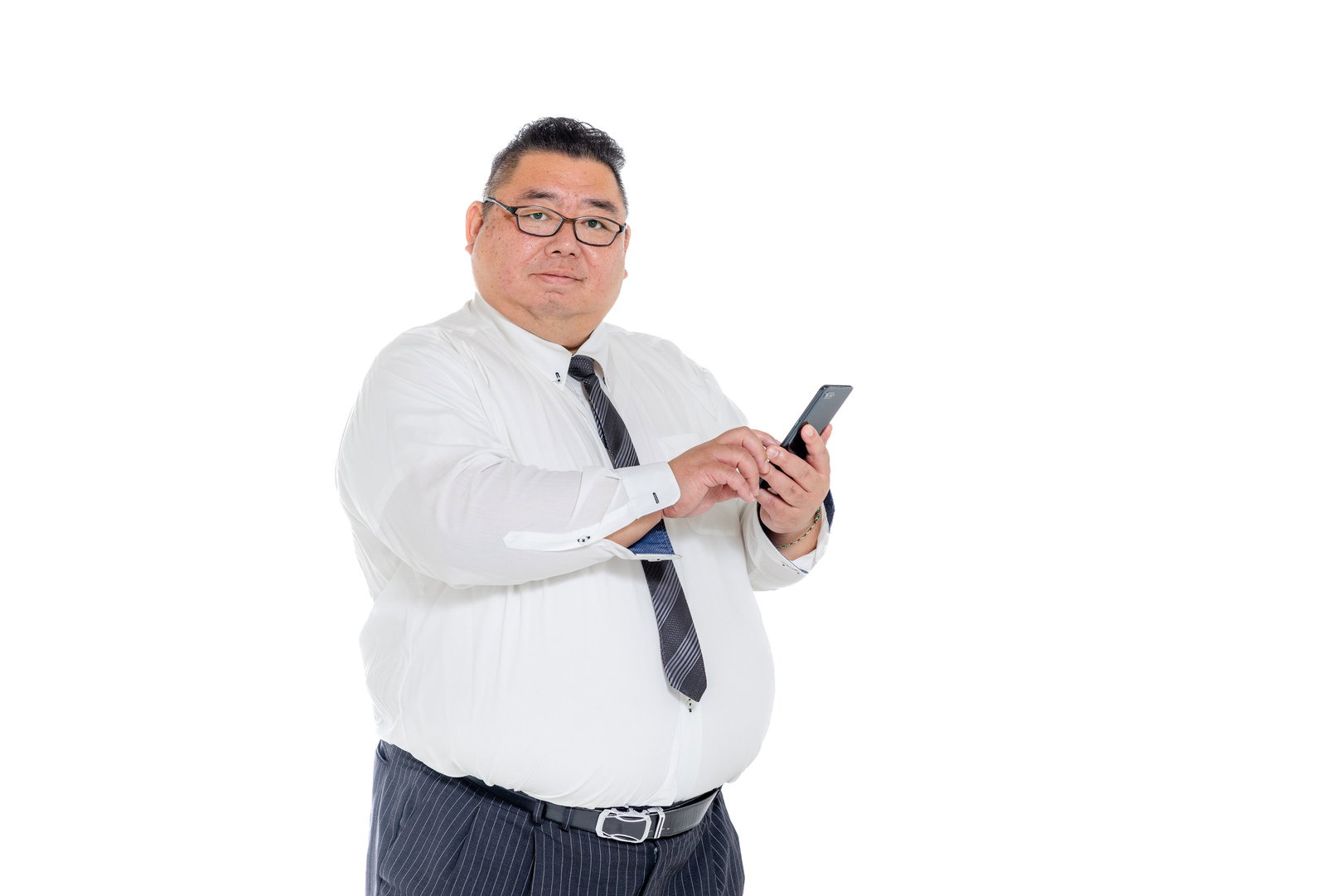 スマホを持ち画面を見つめるスーツ姿の体格の大きな男性［モデル：ダルマ親方］