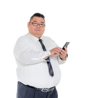 スマホを操作する恰幅のいい会社員男性のビジネスの写真