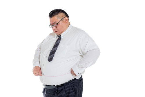 ワイシャツの上からウエストを測定する膨よかな中年会社員