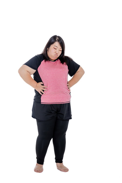 ダイエット中にお腹周りを気にして両手を当てる女性