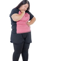 エクササイズ中に頭を抱えて考え事をする女性の写真