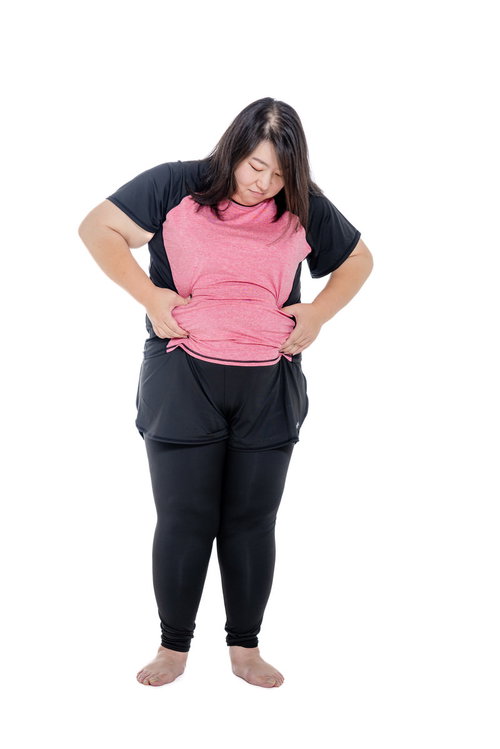 ウエストの贅肉を両手で摘まむエクササイズ前の女性