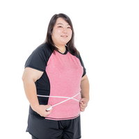 ウエストを測定する女性、メジャーで身体測定、ダイエット・健康管理の写真