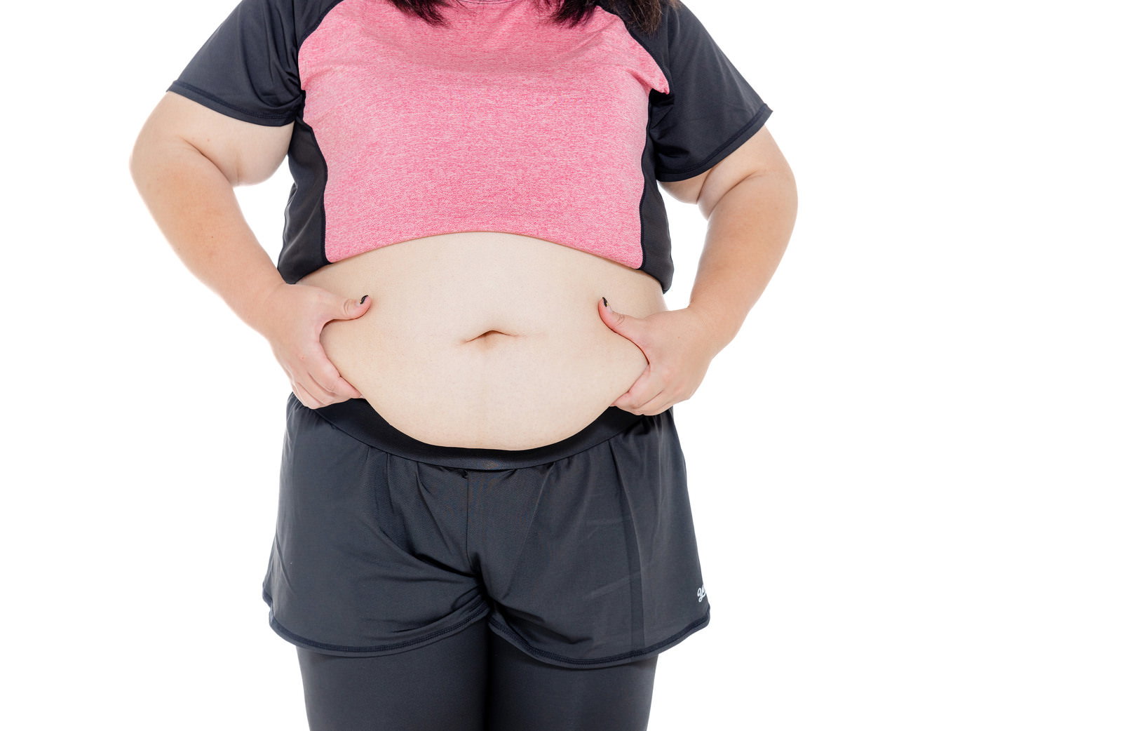 両手でお腹の贅肉をつかむ女性のクローズアップ［モデル：KANA］