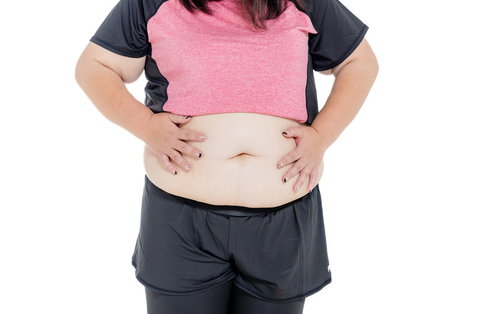 両手でお腹を摩る膨よかな女性のダイエット