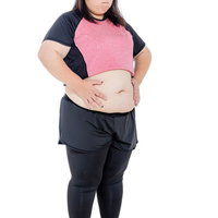 両手をお腹に当てるトレーニング中の女性のボディメイク写真の写真