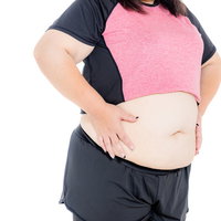 腰の贅肉をお腹に寄せる膨よかな女性のボディの写真