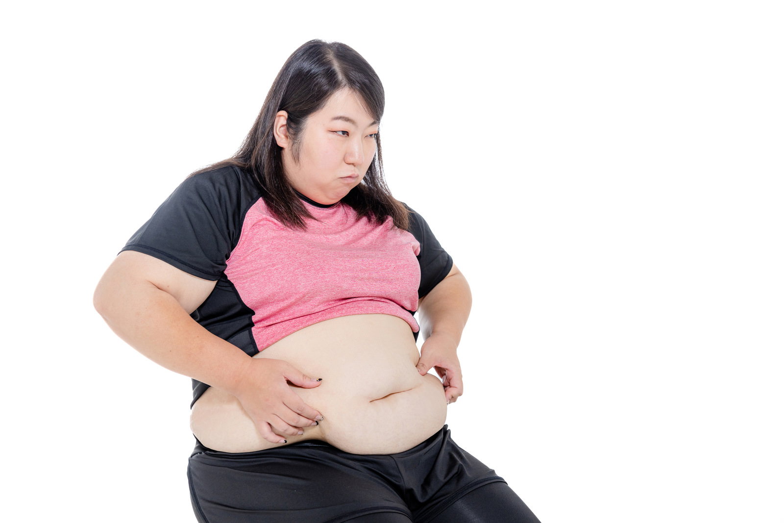腹部の脂肪をつかんで気にする女性の写真［モデル：KANA］
