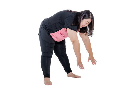 お腹が邪魔して前かがみでストレッチができない肥満女性