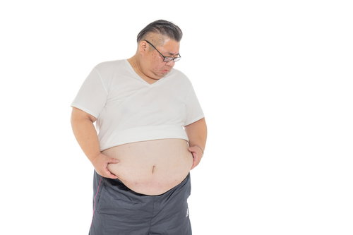 お腹に付いた贅肉をかかえる中年男性のメタボ体型