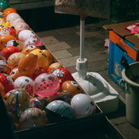 夏祭りの屋台で色とりどりのヨーヨー釣りを楽しむ子どもたちの写真