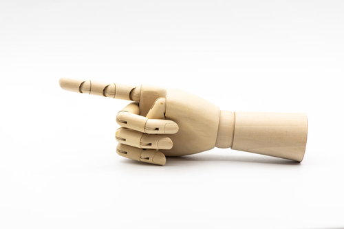 木製の指をさすデッサン人形の手