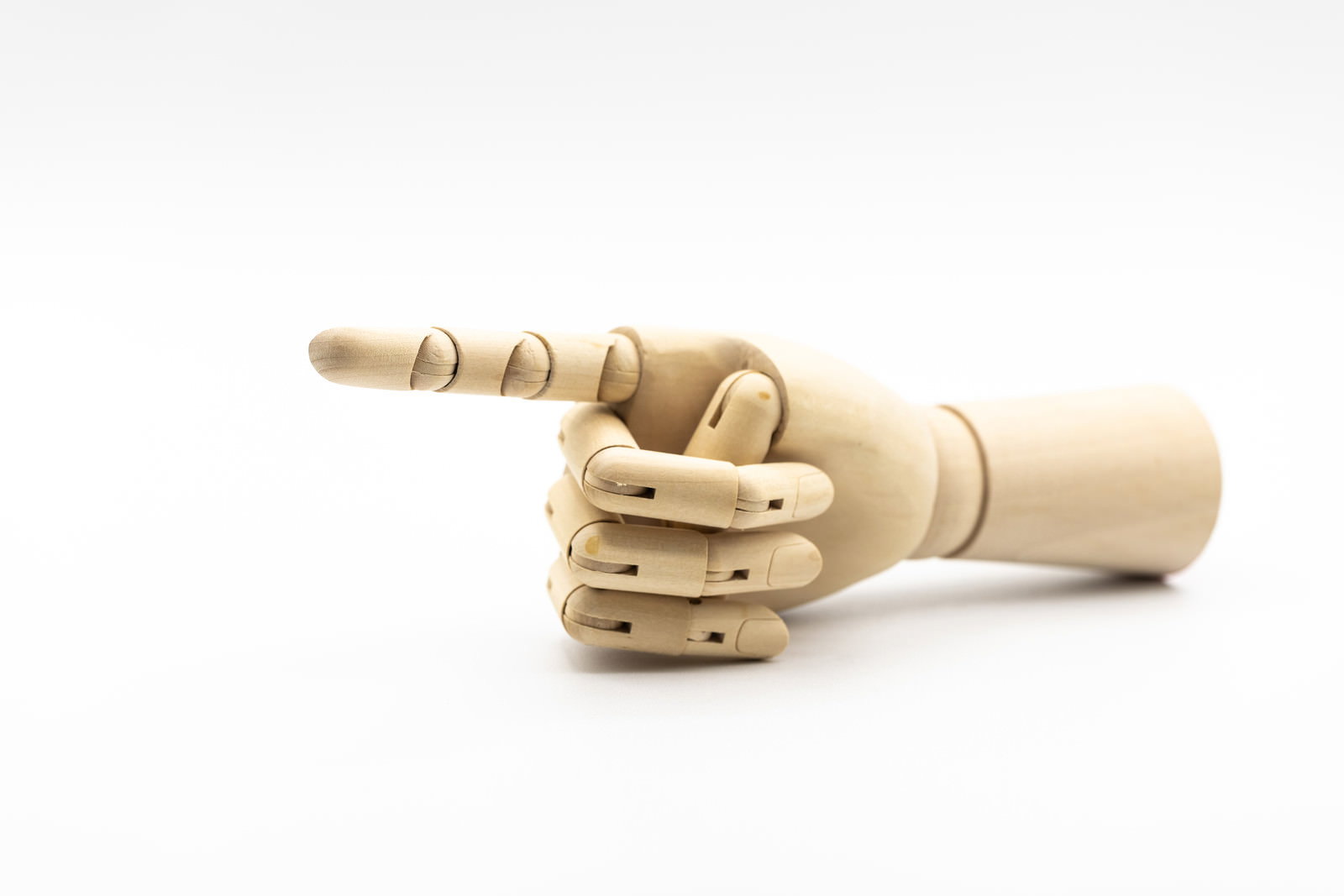 木製のデッサン人形の手が人差し指を立てて指差しているポーズ