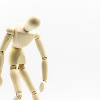 過労でぐったりを表現する木製デッサン人形の写真