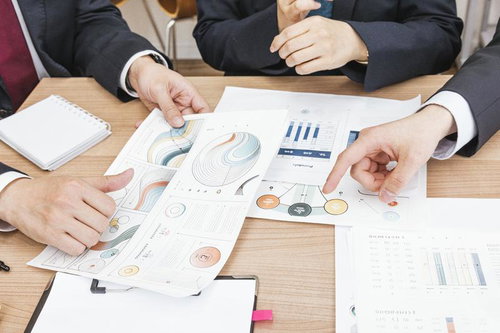 会議室のデスクで資料を広げて打ち合わせする様子