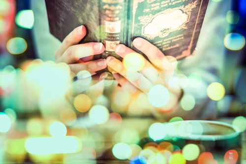 騒がしい街のネオン光の中でほっと一息、洋書を手にした静寂