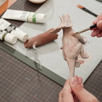 恐竜のプラモデルに肉感を出すための色を置いているところの写真