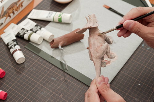 恐竜のプラモデルに肉感を出すための色を置いているところ