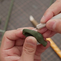 セラミックのカンナでプラモデルのパーティングラインを削る作業の写真