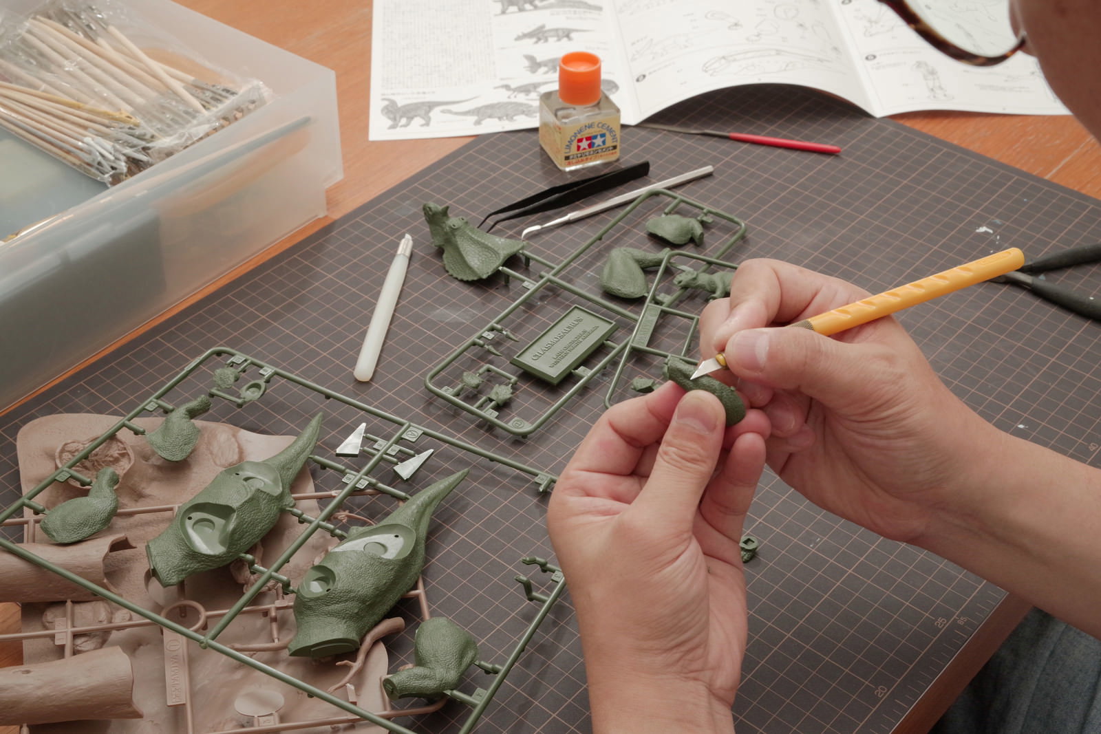 デザインナイフでプラモデルのゲート処理をしている手元