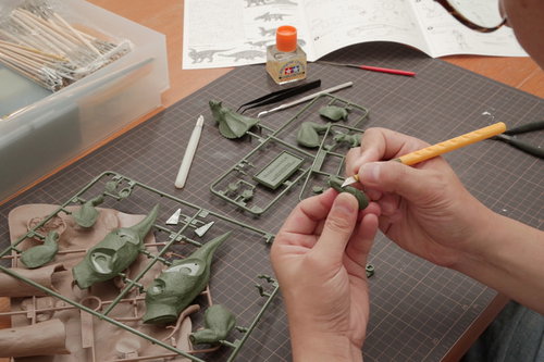 デザインナイフでプラモデルのゲート処理をしている手元の工作風景