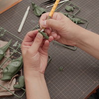 プラモデル製作でゲート処理するデザインナイフを持つ手元の写真