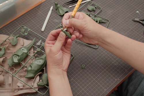 プラモデル製作でゲート処理するデザインナイフを持つ手元