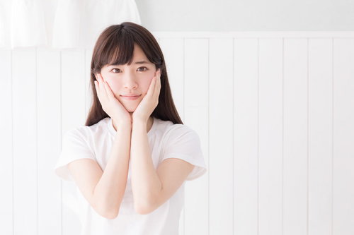 両手を顔に添える色白の女性のスキンケアと美肌ケア