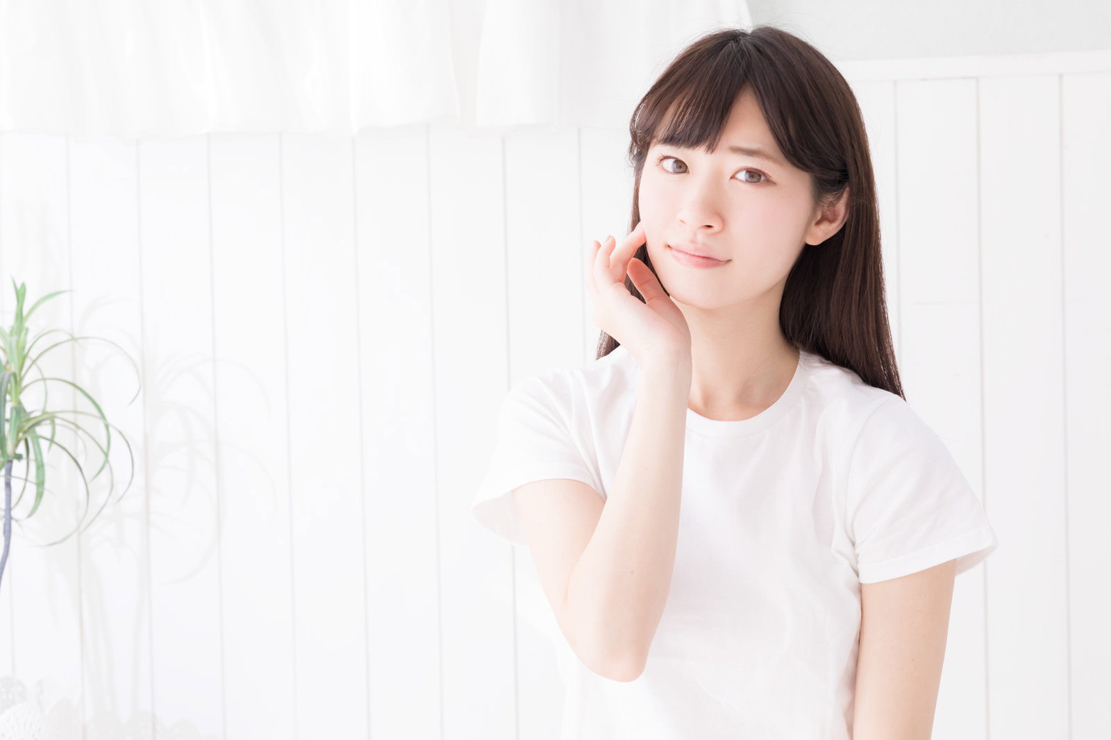 白いTシャツを着た色白の女性が手を口元に当てて不安そうな表情を見せている［モデル：川子芹菜］