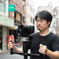 ジンバルを使って手ブレの少ない映像を撮影する男性の写真