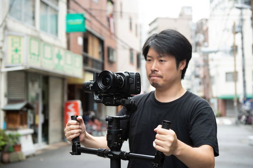 ジンバルを使って手ブレの少ない映像を撮影する男性