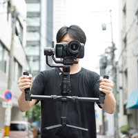 カメラの水平を保つジンバル撮影を行う男性の写真