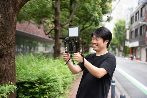 外付けマイクを装着したスマートフォンで動画撮影を楽しむ男性