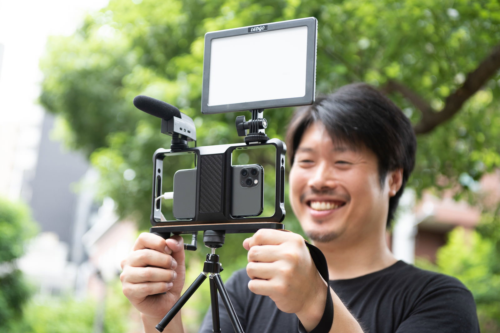 スマートフォンに撮影機材を取り付けてムービー撮影する男性カメラマン［モデル：瀧野恵太］