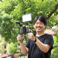 撮れ高に思わずニッコリ、スマホとマイクで動画撮影する男性カメラマンの写真