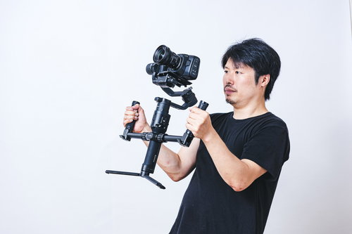 両手でジンバルを使って撮影をするカメラマン