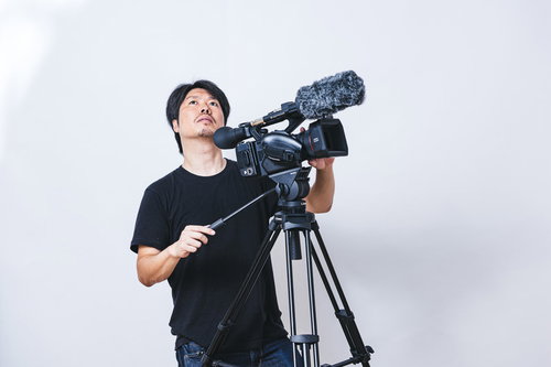 天候の変化を気にしながらムービー撮影を続けるカメラマン