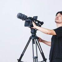 ビデオカメラを上下に動かすカメラマンの撮影作業の写真