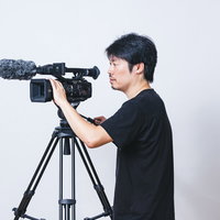 ビデオカメラのモニターを確認しながらフレーミングするカメラマンの写真