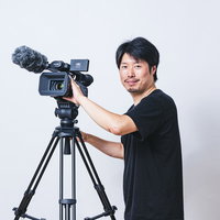 業務用4Kカムコーダーを操作する男性撮影者の写真