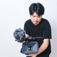 ローアングルからハンディビデオカメラでムービーを撮る男性の写真