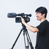 ニコニコしながらムービーを撮影するベテランの写真