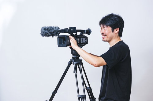 ニコニコしながらムービーを撮影するベテラン