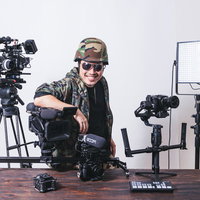 動画機材に囲まれてドヤる男性YouTuberの写真